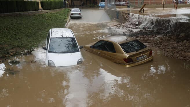 Los servicios de Emergencias de la Generalitat Valenciana están gestionando este sábado más de un centenar de incidencias relacionadas con la lluvia, la mayoría en la provincia de Valencia y especialmente en Torrent y otros municipios al oeste del área metropolitana. En la imagen, dos coches semisumergidos en un paso inundado en Aldaia.