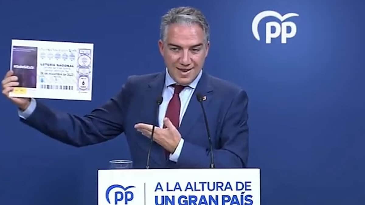 Elías Bendodo (PP) muestra un décimo de lotería con publicidad institucional de la 'Ley sólo sí es sí'.