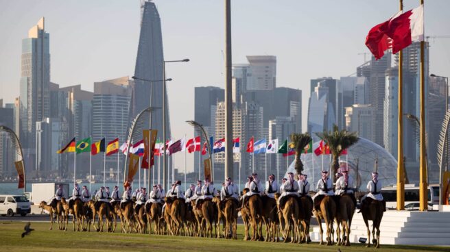 Desfile de camellos frente a las banderas de los países participantes en el Mundial de Qatar 2022.