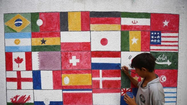 Un niño pinta en Karachi (Pakistán) las banderas de todos los países que participan en el Mundial de fútbol Qatar 2022.