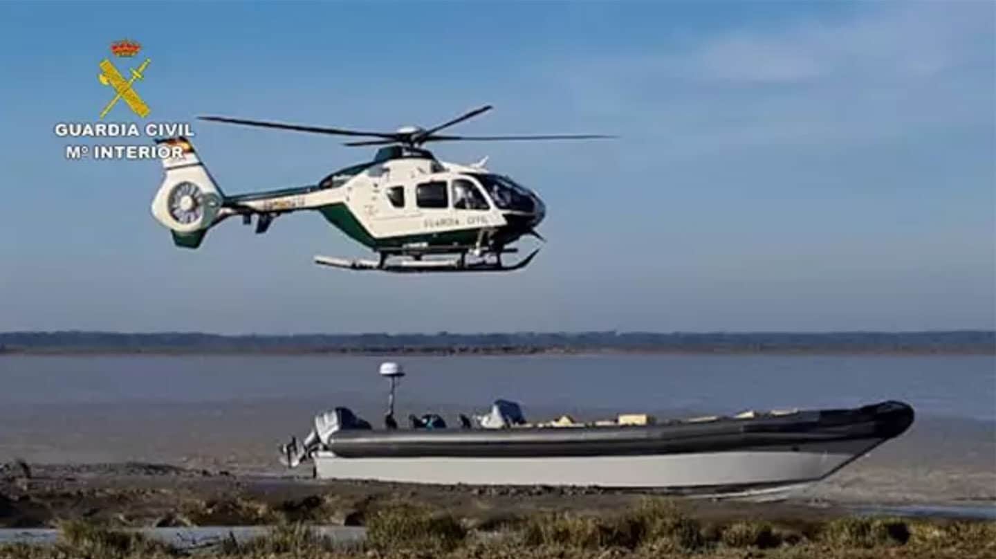 Un helicóptero de la Guardia Civil sobre una 'goma' incautada en una operación contra el narcotráfico en Cádiz.