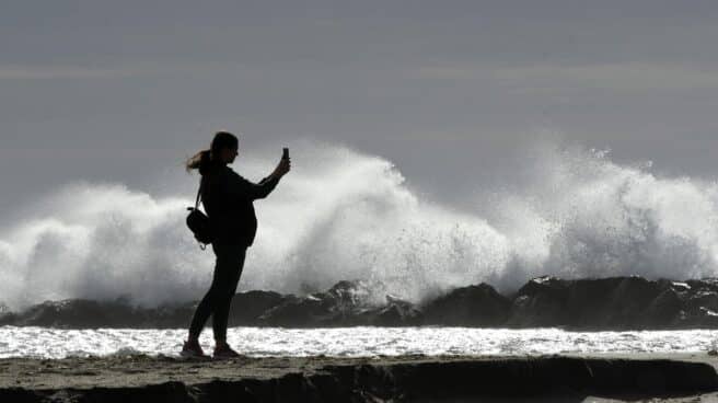 Una persona fotografía las olas en la playa almeriense de El Zapillo, este mes de diciembre.