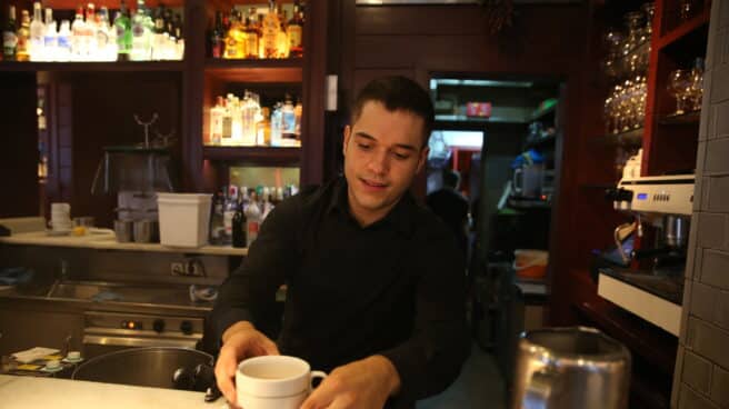 Un empleado prepara un café en el interior de un establecimiento en Madrid.