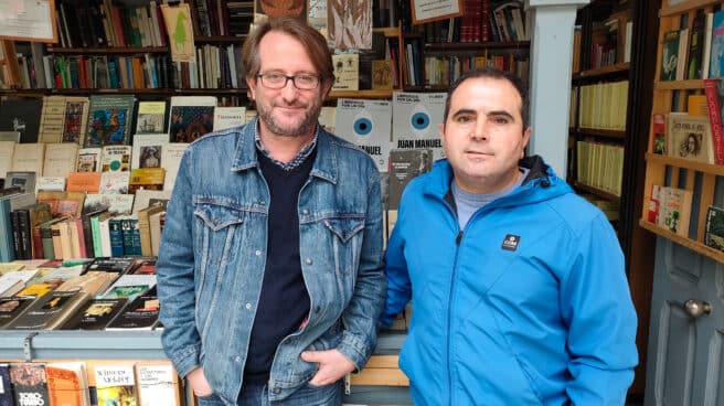 Hugo (derecha), junto a Carlos, uno de sus empleados, en su caseta de la cuesta de Moyano