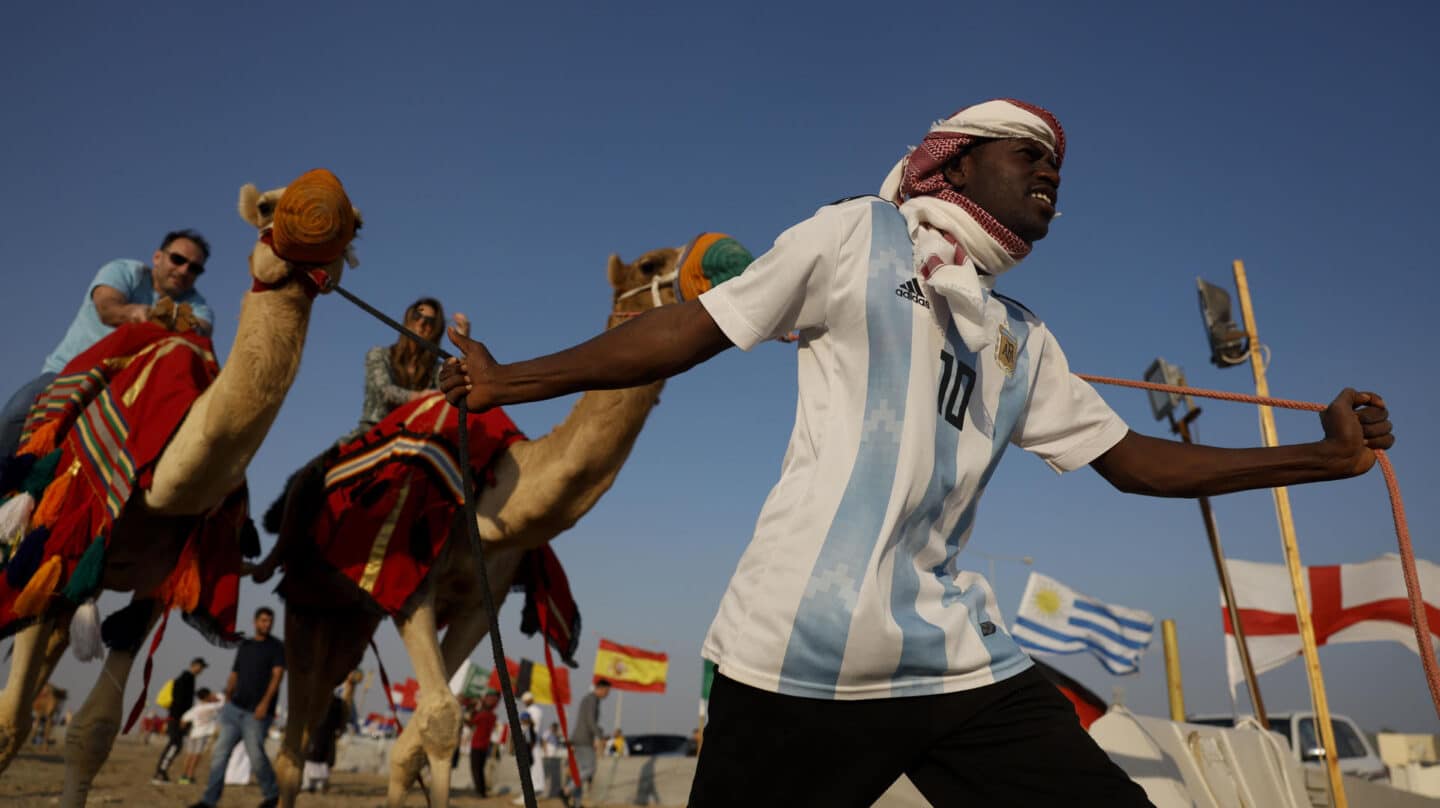 Varios turistas montan en camello en el desierto de Catar, país que celebra estos días el Mundial de fútbol Qatar 2022.