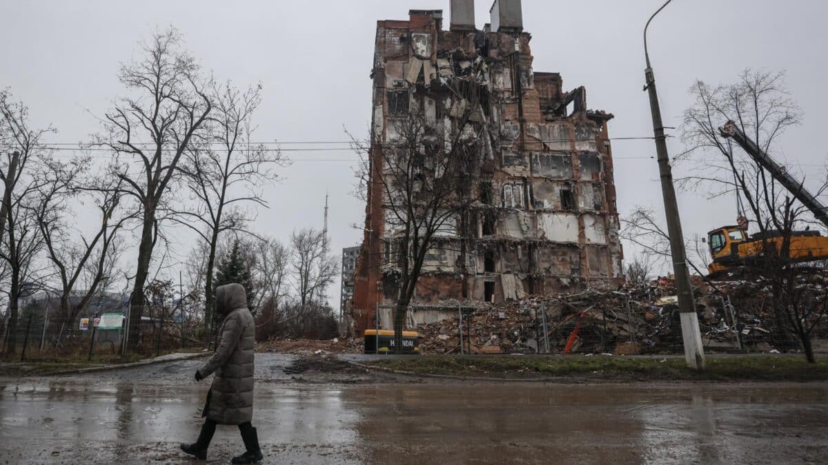 Una mujer pasa frente a un edificio destruido en Mariupol.