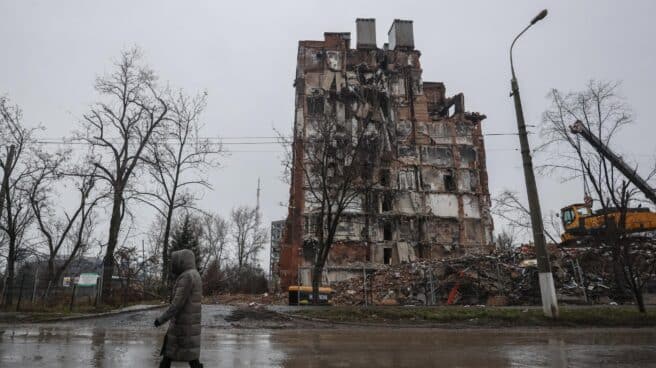 Una mujer pasa frente a un edificio destruido en Mariupol. Una mujer pasa frente a un edificio destruido en Mariupol.