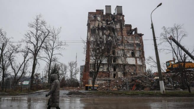 Una mujer pasa frente a un edificio destruido en Mariupol.