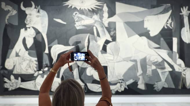 Una mujer fotografía la obra de Picasso 'Guernica' durante la presentación de los actos conmemorativos del Año Picasso, en el Museo Reina Sofía
