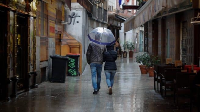 Personas paseando bajo la lluvia con mal tiempo en el puente de diciembre