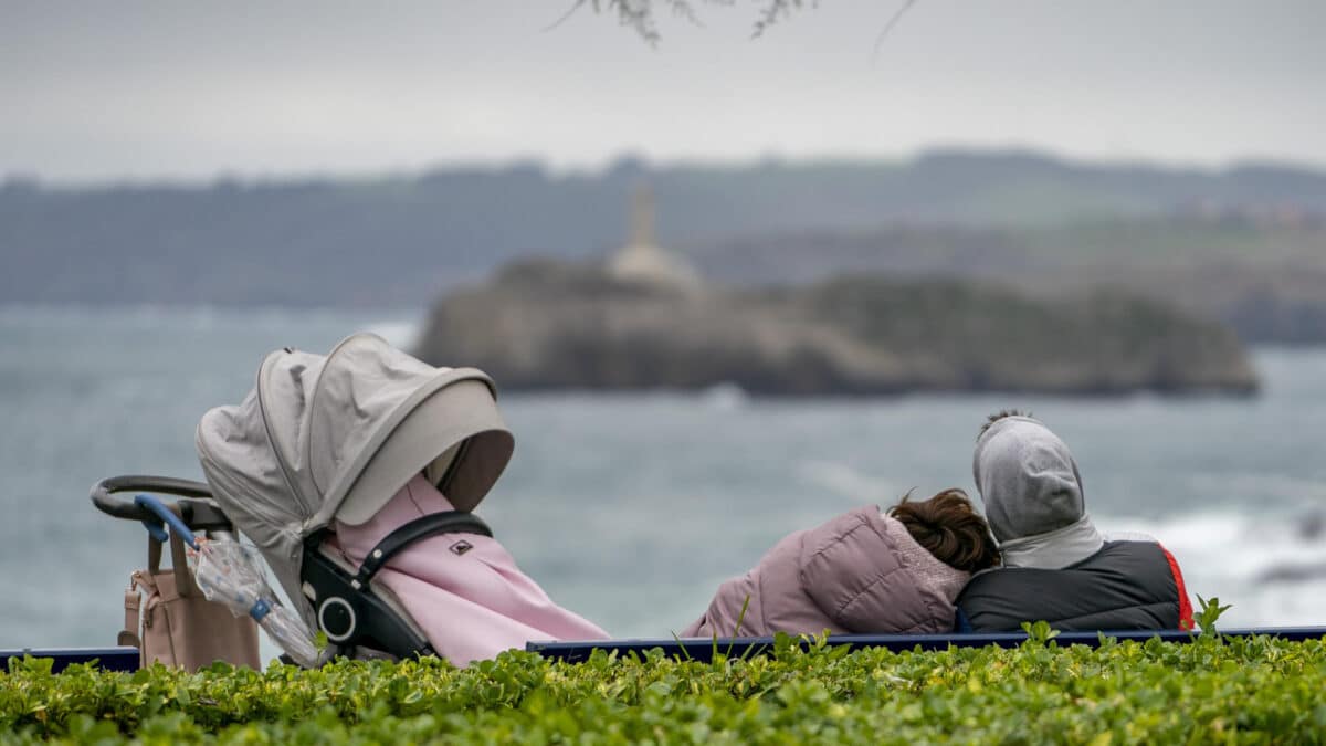 Una pareja, sentada en un banco frente al mar en Santander.