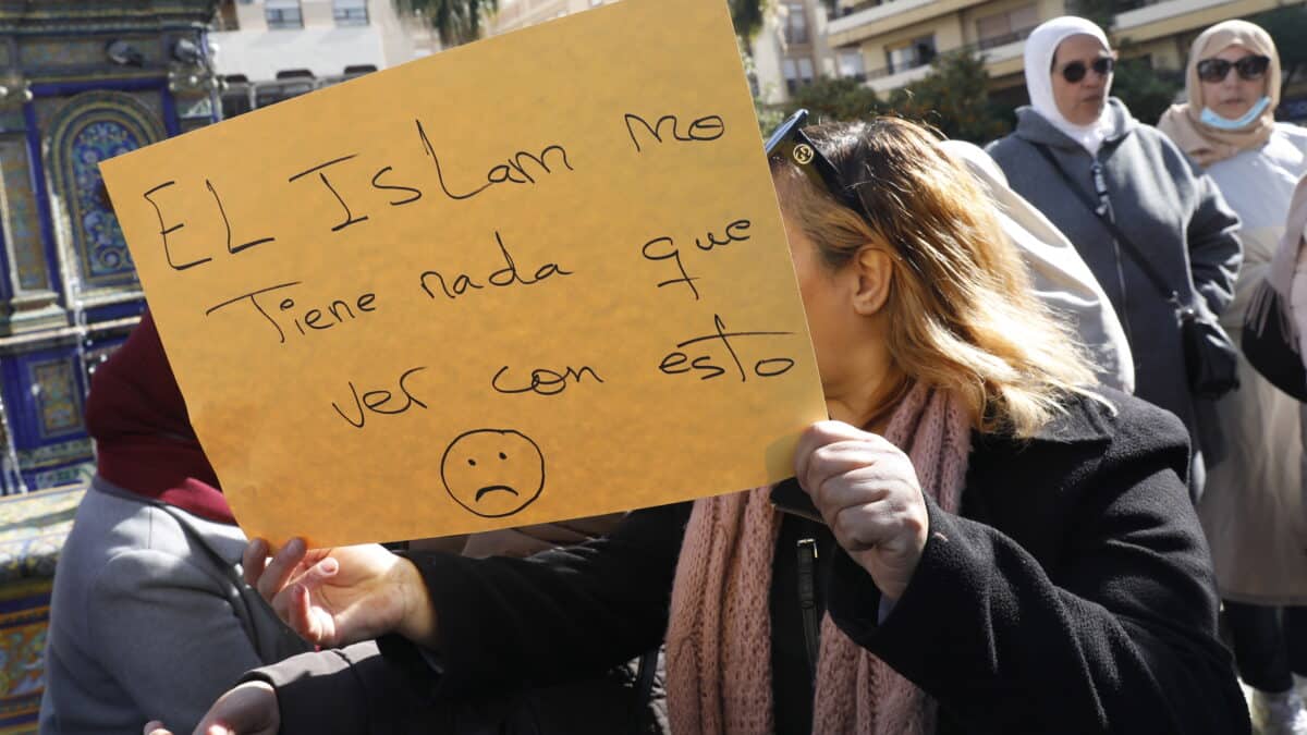 Una mujer sostiene una cartulina con un lema defendiendo el islam, en el sitio donde un hombre de origen marroquí asesinó al sacristan Diego Valencia de la iglesia de la Palma en Algeciras.