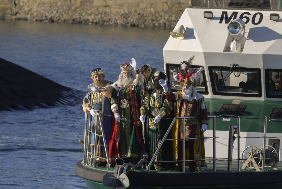  Los Reyes Magos de Oriente Gaspar, Melchor y Baltasar (de izq a der) saludan a los niños mientras llegan al puerto de portillo de Gijón a bordo de una patrullera de la Guardia Civil donde han sido recibidos por miles de niños. 