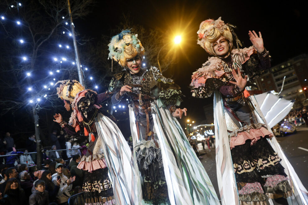 Tres mujeres sobre zancos, y ataviadas con vestiduras de fantasía desfilan y amenizan la cabalgata de Reyes que se celebra este jueves en Madrid. 