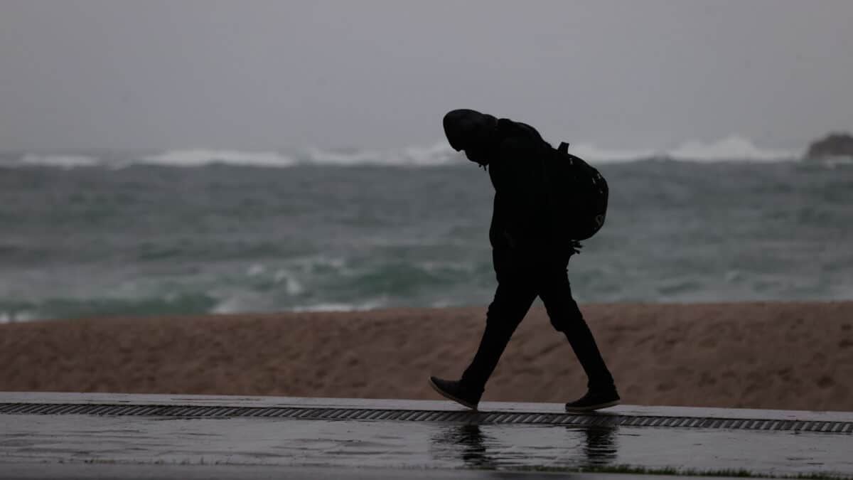 Un hombre caminaba este lunes por el paseo marítimo de A Coruña, en una jornada en la que la borrasca Fien ha obligado a activar el aviso naranja