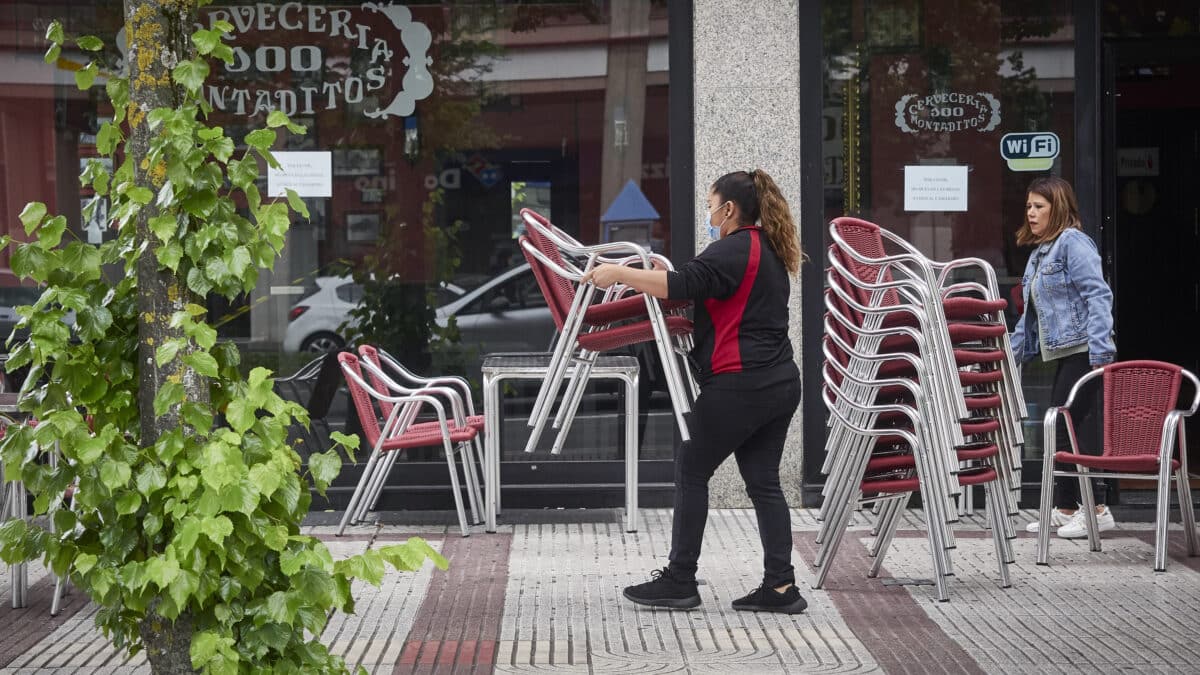 Una camarera prepara la terraza de una Cervecería 100 Montaditos