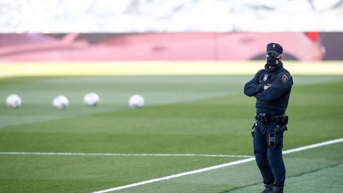 Un Policía Nacional sobre el césped de un campo de fútbol en España