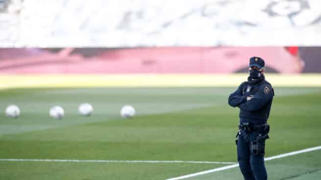 Un Policía Nacional sobre el césped de un campo de fútbol en España Un Policía Nacional sobre el césped de un campo de fútbol en España