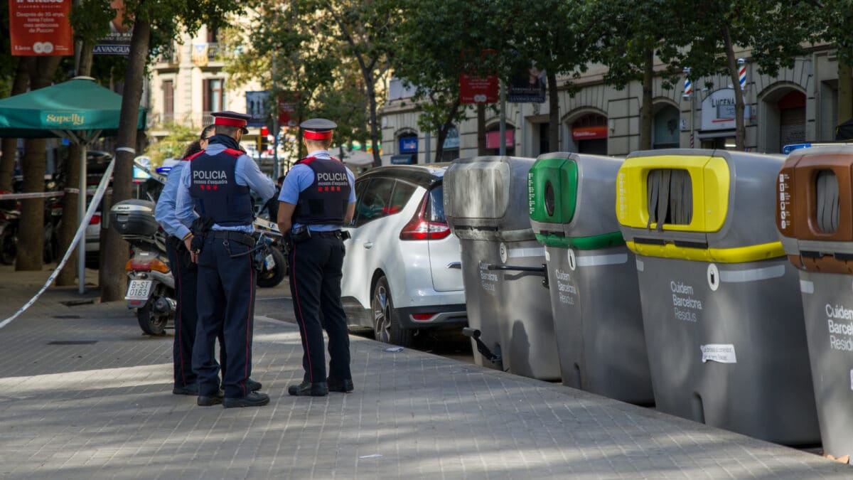Agentes de Policía conversan tras el encuentro de un cadáver en un contenedor del centro de Barcelon