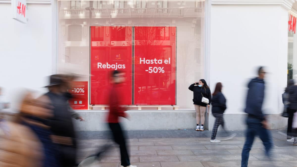 Varias personas caminan frente a una tienda de H&M