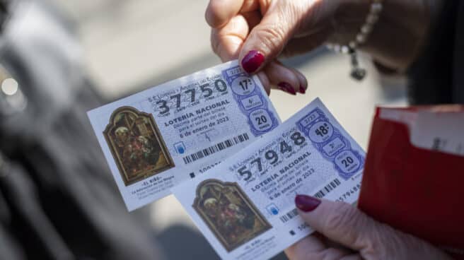 Sorteo de Lotería del Niño 2023: cuánto dinero reparte y dónde verlo Una mujer sostiene dos décimos para ver su premio del Sorteo Extraordinario del Niño.