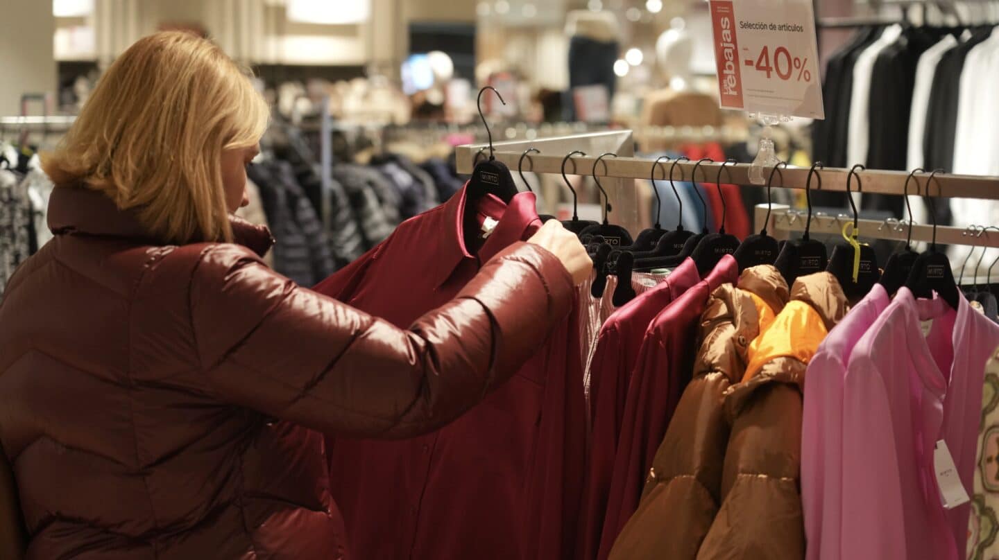 Una mujer observa prendas de ropa.