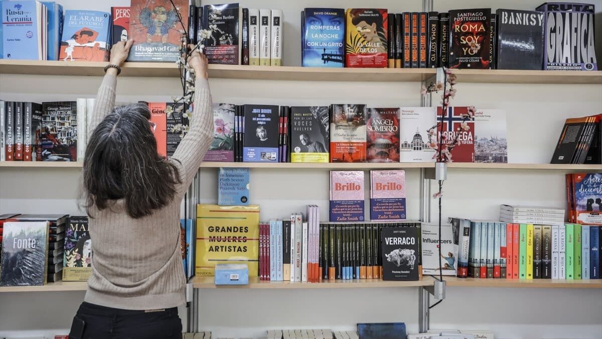 Una mujer coloca un libro en la estantería durante la inauguración de la Feria del Libro 2022 de Valencia.