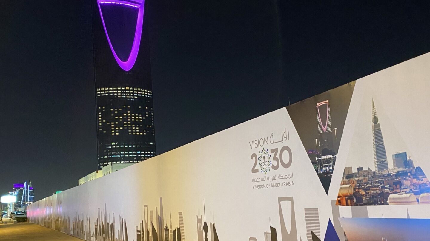 El Kingdom Centre, uno de los rascacielos más llamativos de Riad (Arabia Saudí), de fondo, y las obras del metro con la publicidad de VISION 2030