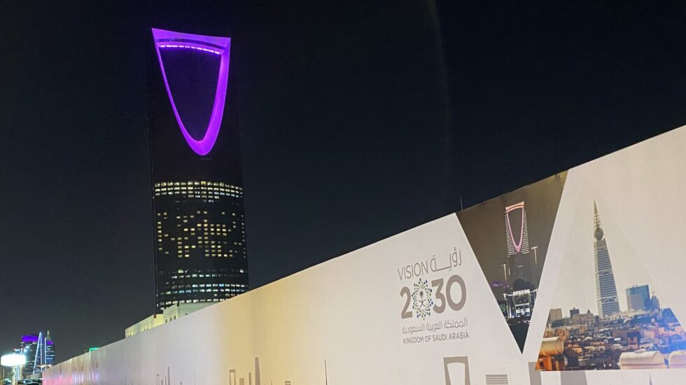 El Kingdom Centre, uno de los rascacielos más llamativos de Riad (Arabia Saudí), de fondo, y las obras del metro con la publicidad de VISION 2030