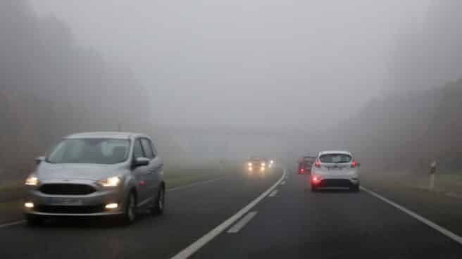 Varios coches con faros antiniebla en una carretera de Lugo. Varios coches con faros antiniebla en una carretera de Lugo.