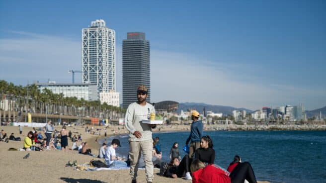 Navidad con altas temperaturas en la playa de Barcelona Un camarero lleva bebidas a las personas que disfrutan de las altas temperaturas en la playa de la Barceloneta, en Barcelona.