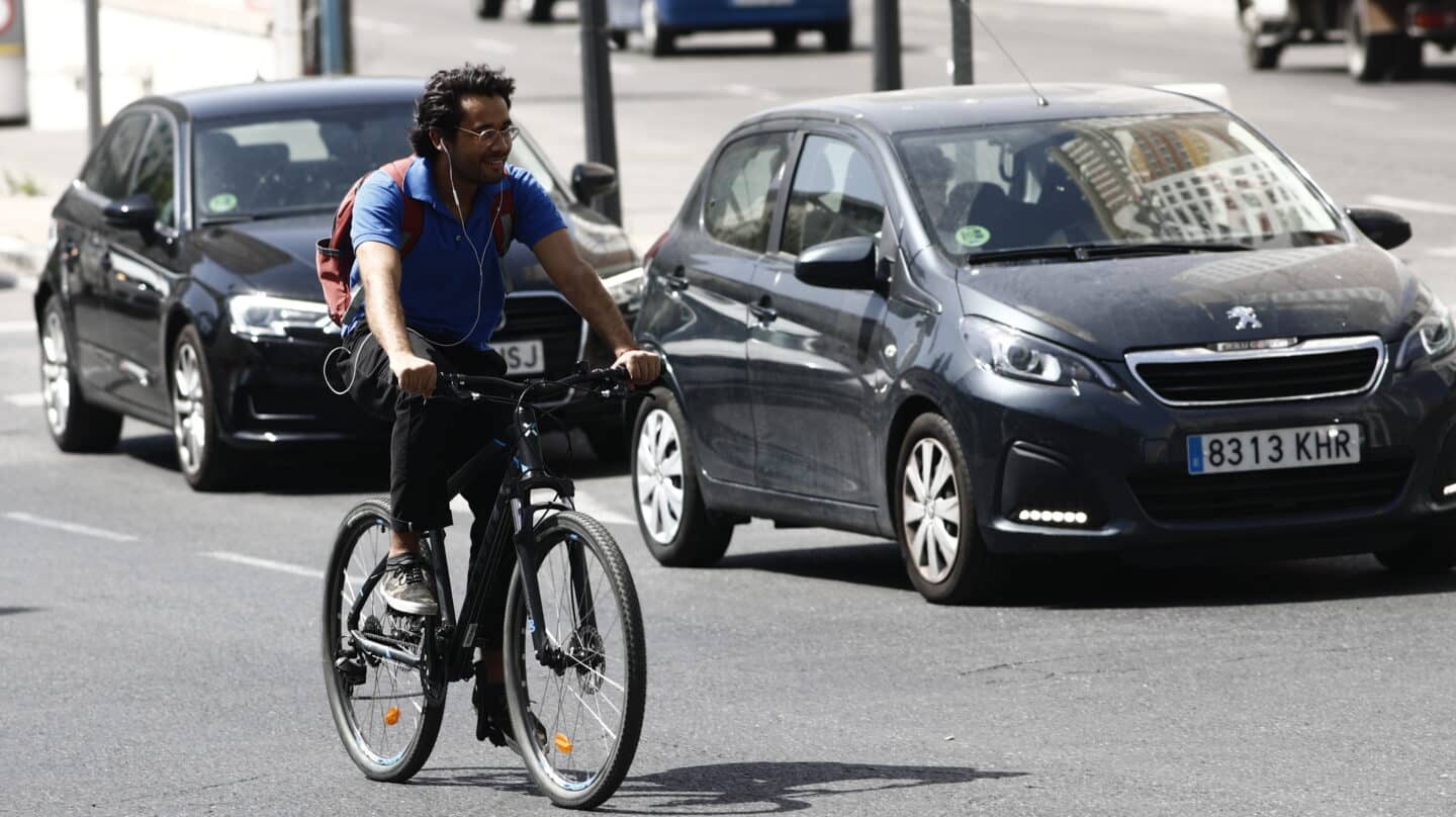 Un ciclista pasea y escucha música en la Plaza de España de Madrid.