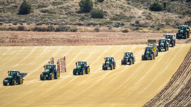 Tractores verdes y rojos participan en una partida gigante de ajedrez