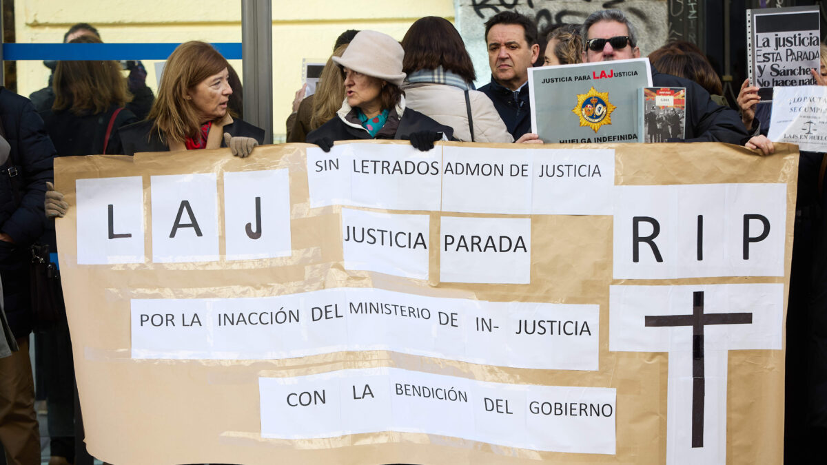 Varios letrados se concentran con una pancarta mientras tiene lugar una reunión del comité de huelga de los letrados con Justicia