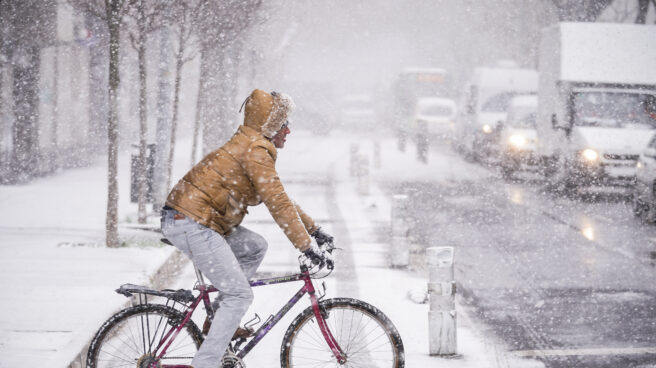 Un ciclista circula por una de las calles de Vitoria-Gasteiz tras la intensa nevada caída sobre la ciudad