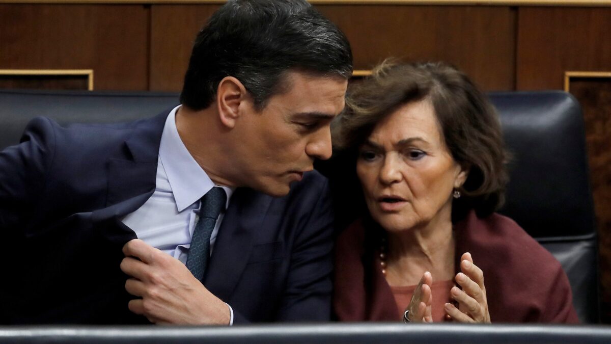 El presidente del Gobierno en funciones, Pedro Sánchez,iz., conversa con la vicepresidenta del Gobierno en funciones, Carmen Calvo,d., en la segunda jornada del debate de investidura de Pedro Sánchez como presidente del Gobierno este domingo en el Congreso de los Diputados.