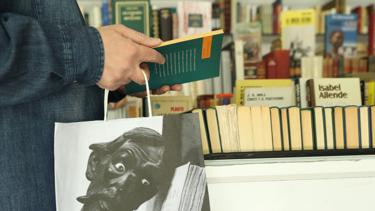 Un hombre mira un libro.