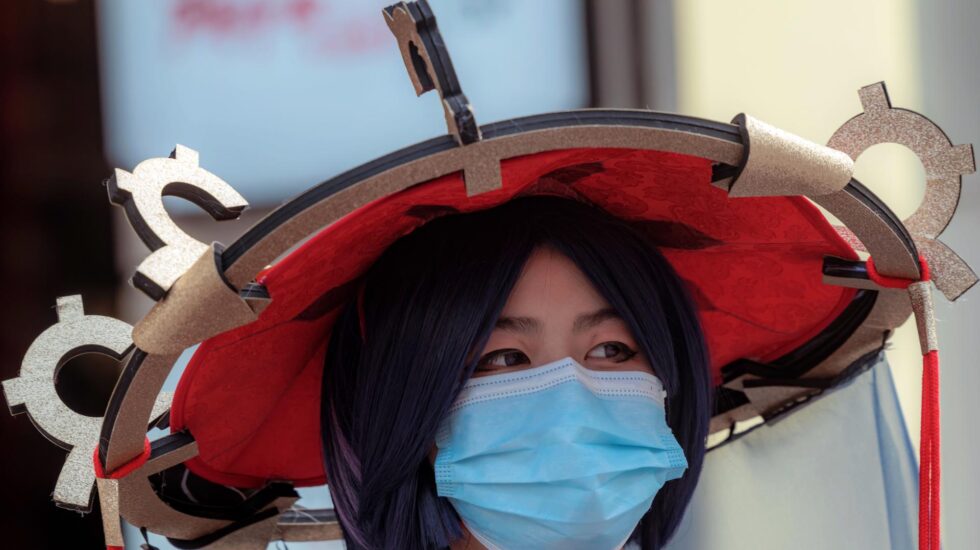 Una mujer con traje tradicional chino y mascarilla en Shanghai (China),