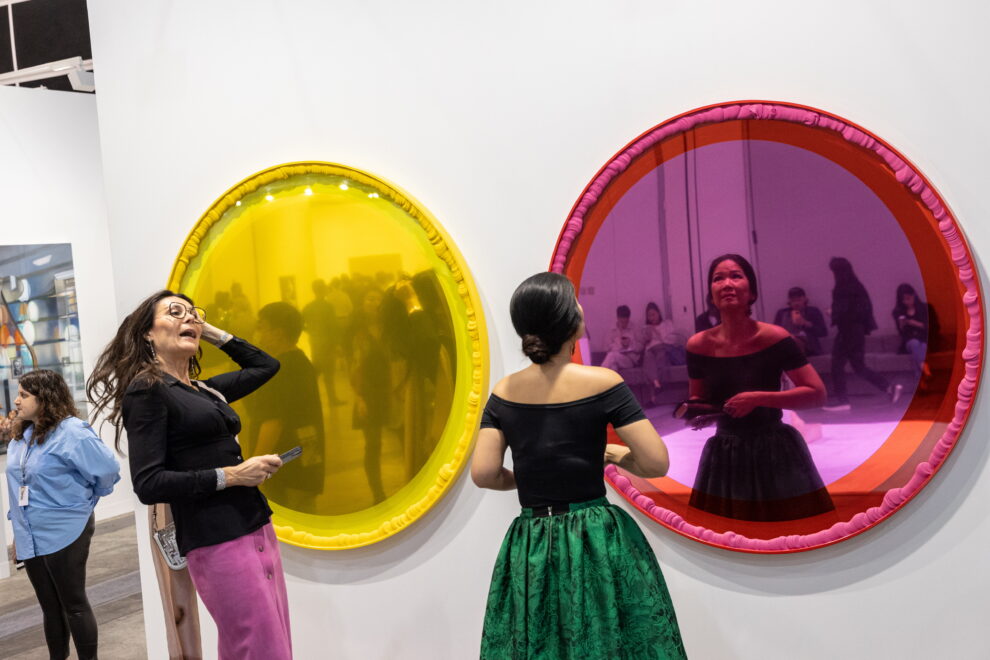 Visitantes miran sus reflejos en espejos durante una vista privada en Art Basel en Hong Kong, China, 21 de marzo de 2023.