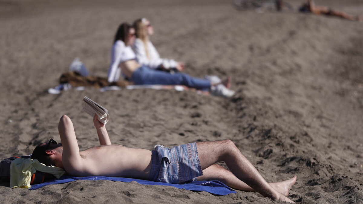 Varias personas toman el sol en la playa de la Malagueta en Málaga este miércoles, cuando suben las temperaturas en España en marzo 2023