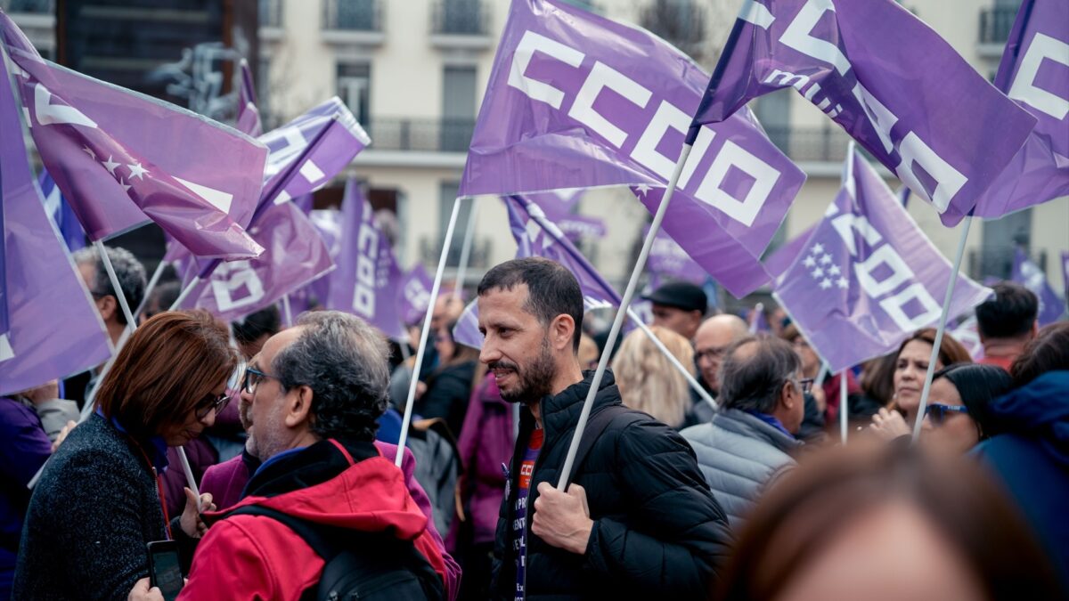 Varias personas con banderas de Comisiones Obreras participan en una concentración con motivo del 8M, en Madrid.