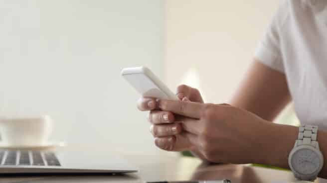 Una mujer consulta el correo electrónico en su teléfono. Una mujer consulta el correo electrónico en su teléfono.