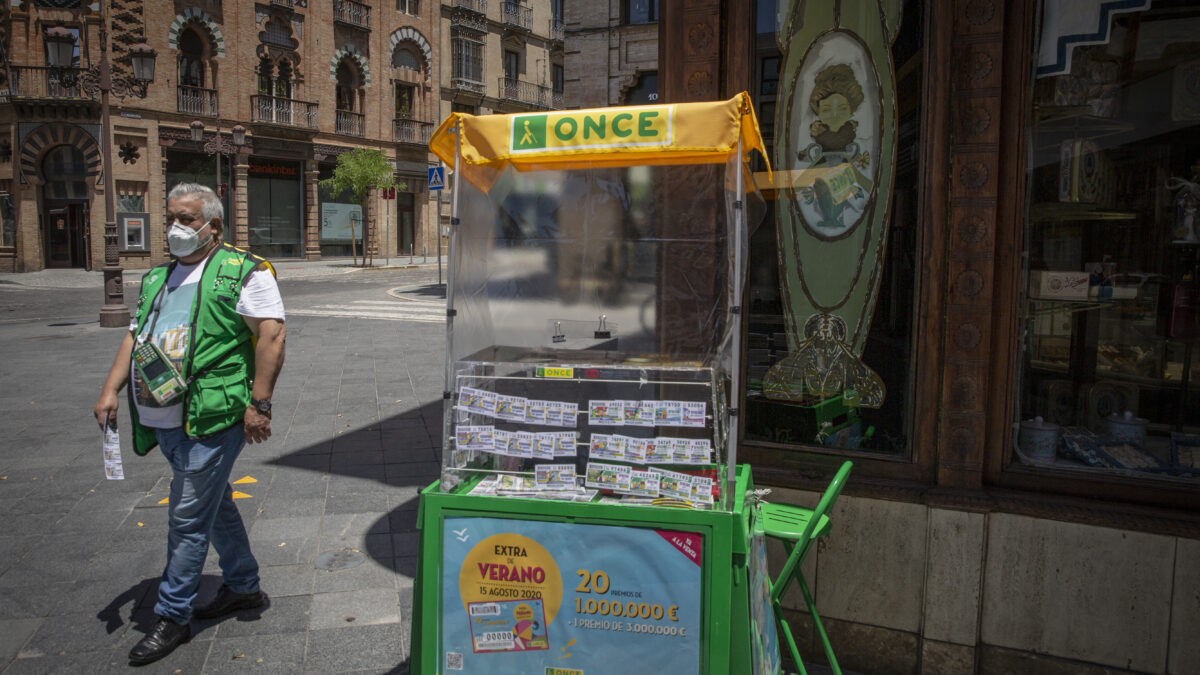 Un vendedor de cupones atiende su puesto el día en el que los 19.000 vendedores y vendedoras de la ONCE vuelven a vender cupones a pie de calle, fecha en la que la Organización inicia los sorteos de sus tradicionales cupones, después de tres mes