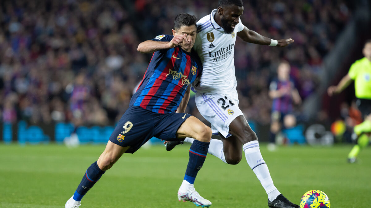 El delantero del Barça, Robert Lewandowski, pugna por el balón con el central del Real Madrid, Antonio Rüdiger.