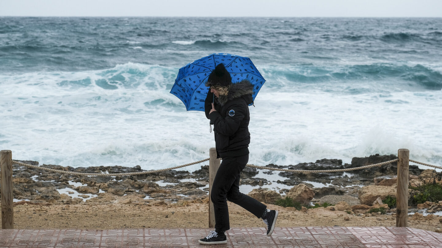 Un mujer se protege de la borrasca Juliette en Ibiza.