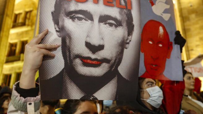 Una manifestante sujeta un cartel mofándose de Vladimir Putin en Tbilisi (Georgia).