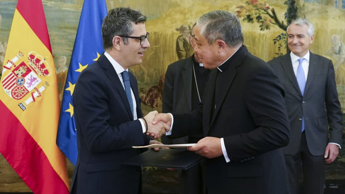 MADRID, 29/03/2023.- El ministro de la Presidencia, Félix Bolaños (i), intercambia documentos con el Nuncio en España, el arzobispo Bernardito Auza (d), durante un encuentro celebrado este miércoles en Madrid.EFE/ Borja Sánchez Trillo