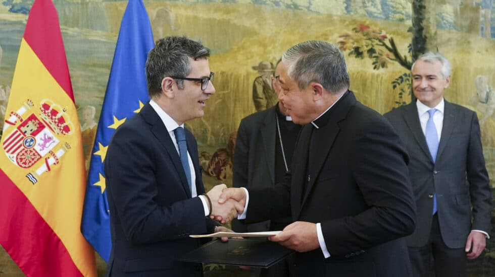 MADRID, 29/03/2023.- El ministro de la Presidencia, Félix Bolaños (i), intercambia documentos con el Nuncio en España, el arzobispo Bernardito Auza (d), durante un encuentro celebrado este miércoles en Madrid.EFE/ Borja Sánchez Trillo