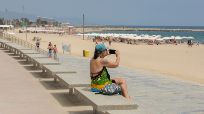 Mujer disfrutando del buen tiempo en España en Semana Santa 2023 en la playa de Barcelona