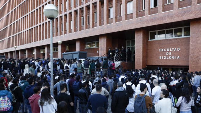 Cientos de personas hacen cola para acceder al examen de las oposiciones a Policía Nacional celebradas en la Facultad de Biología en la Universidad Complutense de Madrid.